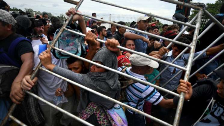 Caravana de migrantes tiran vallas para ingresar a México